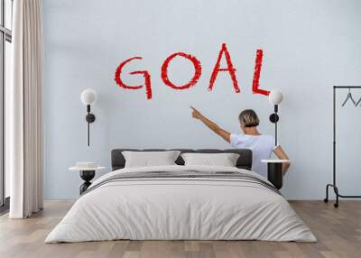 Frau vor einer Wand mit dem Wort GOAL Wall mural