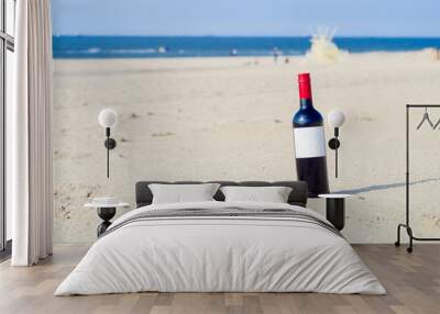 the bottle of red wine with white label on the sunny beach Wall mural