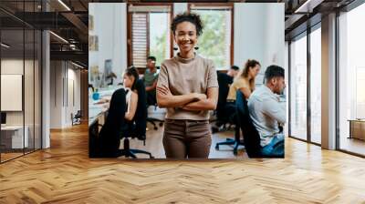 Crossed arms, happy and portrait of woman in office with pride for management, creativity or career. Team, confident and young female public relations worker with smile at startup agency in Spain. Wall mural