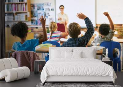 Education, question with group of children in classroom and raise their hands to answer. Learning or support, diversity and teacher teaching with young students in class of school building together Wall mural