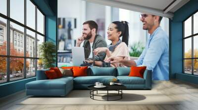 Optimism helps us persevere and conquer. Shot of a group of young designers listening to a presentation in an office. Wall mural