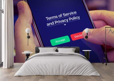 Smartphone user refuses to accept Terms of Service and Privacy Policy mobile app. Dark app interface with Accept and Decline buttons. Finger touches the Decline button Wall mural
