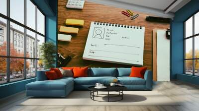 A notebook with a diagram of the persona is on the desk. Wall mural