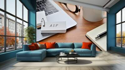 On a desk with a laptop, glasses, coffee, and a notebook, a vocabulary book was placed open There. The word ASP is there. It's an acronym that means Application Service Provider. Wall mural