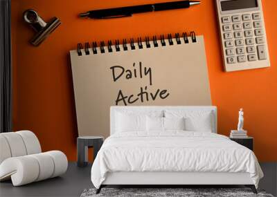 There is a notebook with the word Daily Active Users. It is eye-catching image. Wall mural