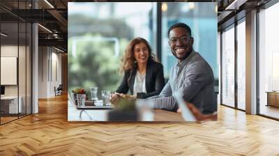 Happy business team working together in a conference room, with the leader smiling and laughing during a meeting at the office table. Suitable for illustrating teamwork and collaboration in corporate  Wall mural