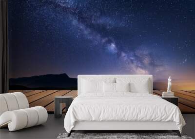 wooden table under a starry night sky creating a serene and magical outdoor setting Wall mural