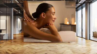 Relaxing spa treatment. European woman receiving back massage from professional masseuse at beauty salon, side view, copy space Wall mural