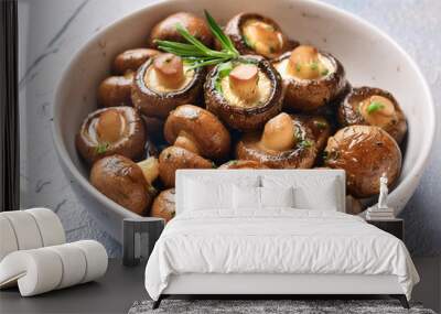 A white bowl filled with roasted button mushrooms, garnished with rosemary and herbs Wall mural