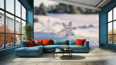 Two intricate snowflakes rest on a snowy surface with a soft-focus forest backdrop Wall mural