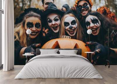 Happy young people dressed up as different spooky characters, with scary makeup on faces having fun at Halloween costume party. Group portrait of adult friends with traditional smiley jack-o-lantern Wall mural