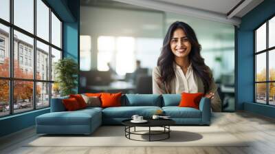 Portrait of indian businesswoman wearing shirt and standing outside conference room. Portrait of happy business lady wearing spectacles and looking at camera with copy space. Satisfied proud female. Wall mural