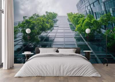 Selective focus on tree and eco friendly building with vertical garden in modern city. Green tree forest on sustainable glass building. Office building with green environment. Go green concept. Wall mural