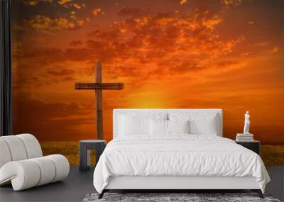 Wood cross of Jesus crucifixion and resurrection with sunset background. Christianity and spiritual concept. Wall mural