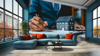 A real estate agent in a blue suit is signing a house contract. A photograph of a home icon with a hand holding a pen on top. highlighting houses or buildings, emphasizing realism and detail. Wall mural