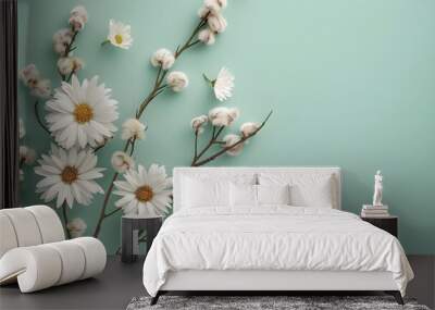 Beautiful spring floral composition with white daisies and willow branches on a light green background, shown in a flat lay top view. A bouquet of fresh daisy flowers and small fluffy catkins is lying Wall mural