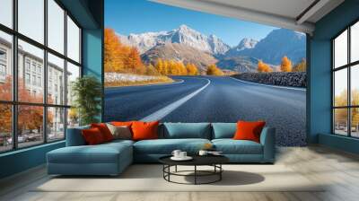 A road with a mountain in the background. The road is empty and the sky is clear. The road is lined with trees and the leaves are changing colors Wall mural