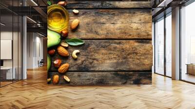 A wooden table with a bunch of avocados and nuts on it. The avocados are cut in half and the nuts are scattered around them Wall mural