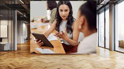 Do you get what Im saying. a young businesswoman using a digital tablet while having a discussion with a colleague in an office. Wall mural