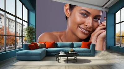 Her soft skin makes her smile. Portrait of a beautiful young woman posing in the studio. Wall mural