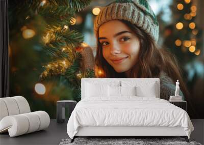 happy young girl decorating christmas tree in living room. Wall mural