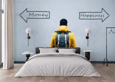 Man in yellow coat standing in front of white wall with arrows money, happiness, decision making concept, mindset, background, copy space area, template Wall mural