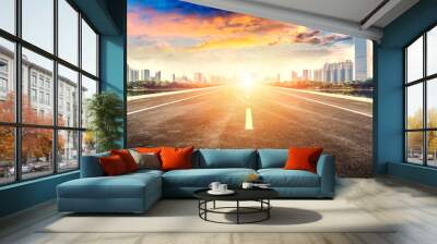 An empty asphalt highway straight ahead to a modern city. Wall mural