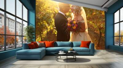 Handsome groom and bride posing outdoor, bride holding bouquet of flowers in hands Wall mural