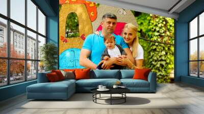 Happy family have fun outdoors, female and male play with baby boy Wall mural