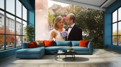 Joyful bride and groom embracing outdoor Wall mural