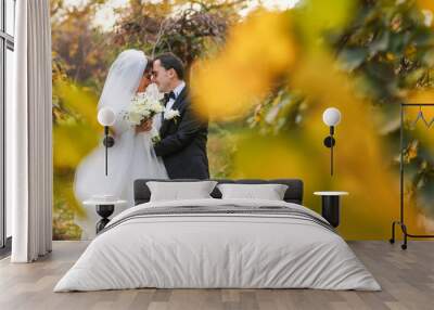 Stylish couple of happy newlyweds posing in the park on their wedding day. Perfect couple Wall mural