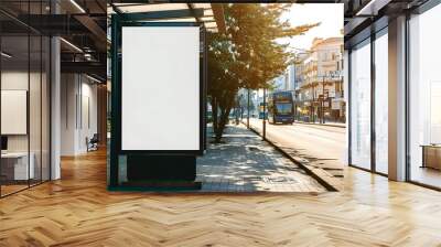 Vertical blank white billboard at bus stop on city street. In the background buildings and road. Mock up. Poster on street next to roadway. Sunny summer day. Wall mural