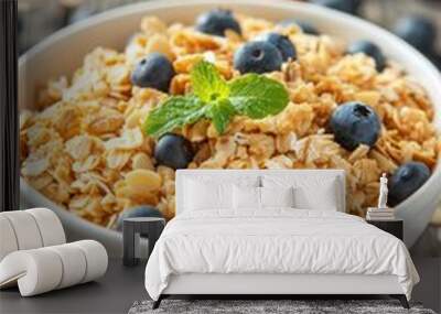 A bowl filled with crunchy granola topped with fresh blueberries and mint leaves. The concept of a healthy breakfast. Wall mural