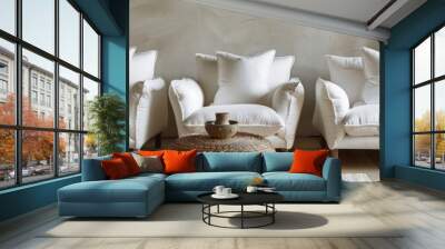 A white sofa and two matching armchairs sit against a textured wall, a wicker coffee table sits in front Wall mural