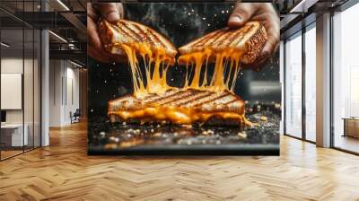 Two slices of perfectly grilled bread are pulled apart, revealing gooey melted cheese stretching between them in a warm kitchen setting Wall mural