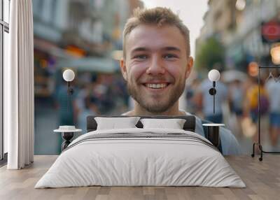 Self-Portrait of Smiling Brunette Man in Fitted T-Shirt, Vibrant City Street Background, Blurred Passersby, Natural Lighting Accentuating Details Wall mural