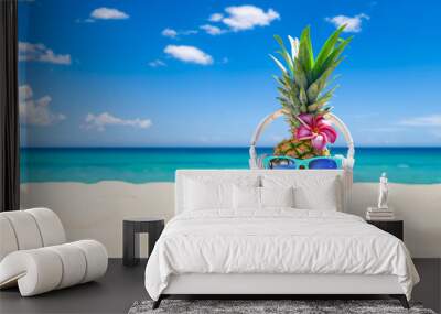 Pineapple with sunglasses and headphones at tropical beach - Holiday Vacation Concept Wall mural