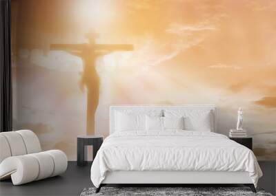 silhouette Jesus Christ crucifixion on cross over orange sunset light background, prayer and praise religion concept Wall mural