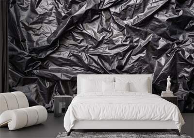 Crumpled black plastic texture background close-up Wall mural