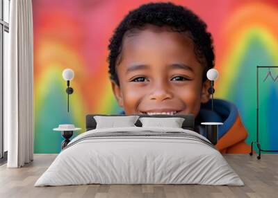 Joyful African-American boy radiating happiness against a vibrant rainbow backdrop Wall mural