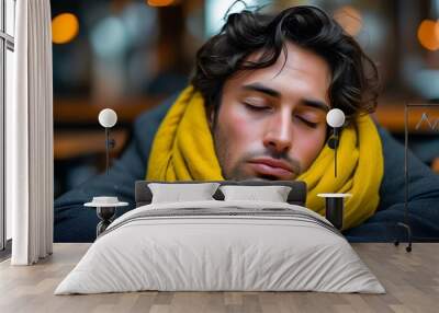 Man napping at desk adorned with yellow scarf, embodying exhaustion and a moment of tranquility in a busy environment Wall mural