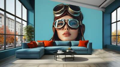 Retro pin-up portrait of a beautiful young woman in aviator goggles against a blue background, embracing vintage fashion and steampunk style for Womens Day celebration Wall mural