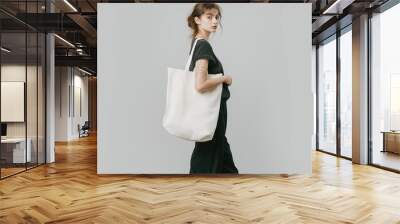 Tote bag mockup. Style person with shopping eco tote bag mock-up. Minimalist modern fashion look with dim clothing. Template mockup nature tote bag. Realistic style photo Wall mural