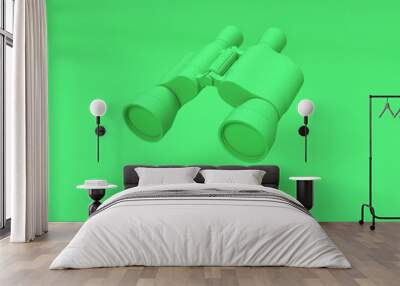 Green binoculars isolated on green background with copy space Wall mural