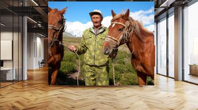 asian man holding two horses Wall mural