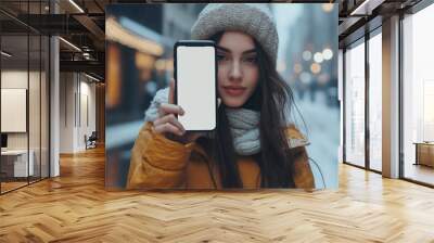 A young woman shows a blank phone screen to the camera Wall mural