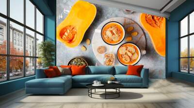 Roasted butternut squash soup with cream and pumpkin seeds on two white mugs. Wall mural