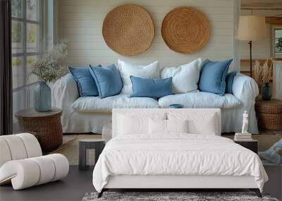 Coastal cottage living room with a fresh, airy atmosphere, featuring all-white furniture, light blue accent pieces, wicker baskets, and a driftwood coffee table, illuminated by soft natural light, Wall mural