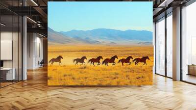 A group of wild horses galloping across a vast desert under a clear blue sky  Wall mural