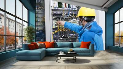 Man connecting network cables to switches Wall mural